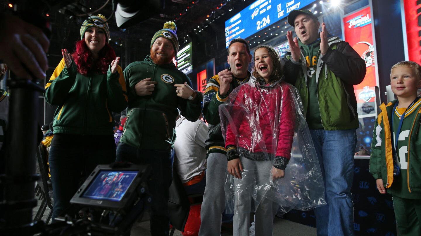 A group of Green Bay Packers fans cheer for a broadcast cameraman during the fourth round of the NFL draft from Selection Square at Draft Town in Grant Park Saturday, April 30, 2016, in Chicago.