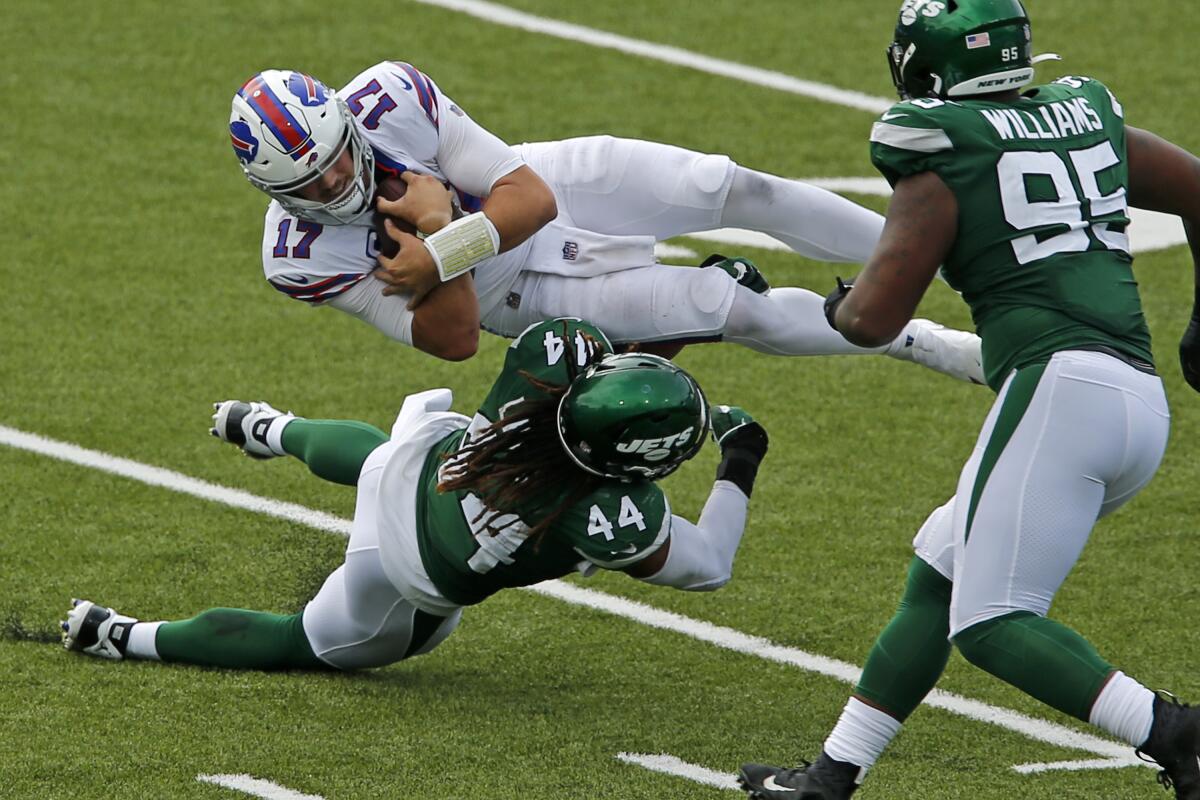 Buffalo Bills quarterback Josh Allen is upended by New York Jets linebacker Harvey Langi during Sunday's game.