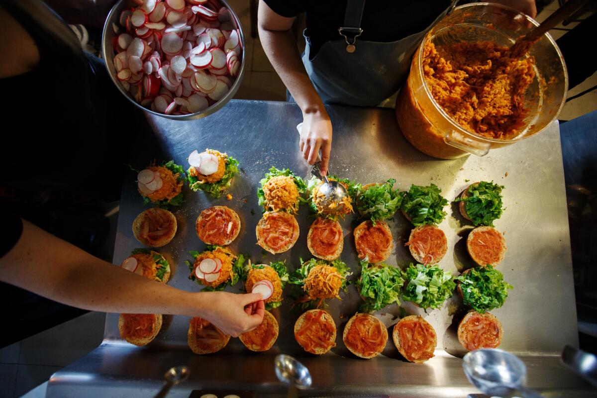 The crew at Los Loosers prepares spicy pozole sandwiches at their store in Mexico City.