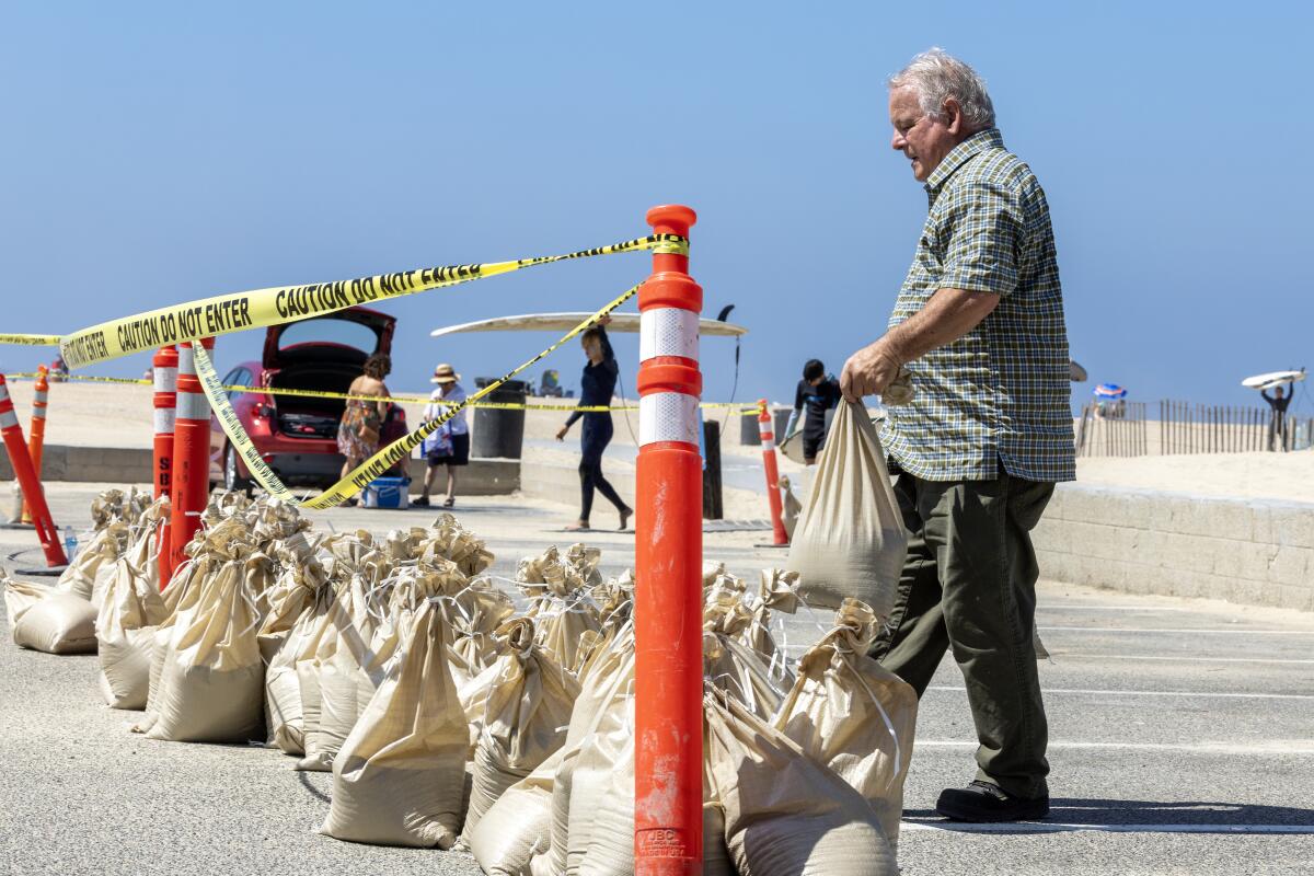  John Straub, right, a CERT volunteer, loads dozens of sandbags in Seal Beach for local residents to fortify their homes.