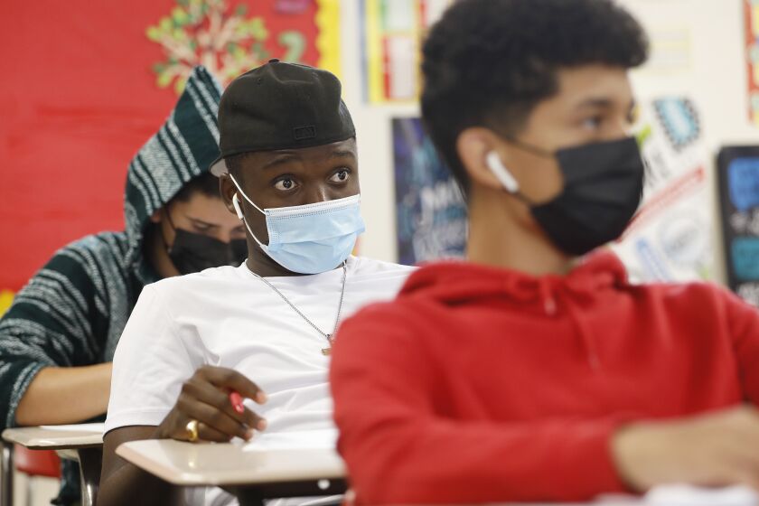 HAWTHORNE, CA - JULY 26: 12th grade student Patrick Ugwuezumba, middle, is masked in the Math 2 class of teacher Cordell Haynes, as students attend the last two day's of summer school at Hawthorne High School in the South Bays Centinela Valley Union High School District which didn't reopen in the spring, and instead reopened for in-person summer instruction. The students are finishing 5 weeks of the summer school session. Various summer schools are in session, and some districts see them as a trial run for the fall when it comes to protocols like distancing and masking mandates. Hawthorne High School on Monday, July 26, 2021 in Hawthorne, CA. (Al Seib / Los Angeles Times).