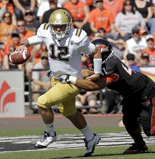 UCLA quarterback Richard Brehaut tries to escape the pressure of Oregon State linebacker Feti Unga in the first half Saturday.