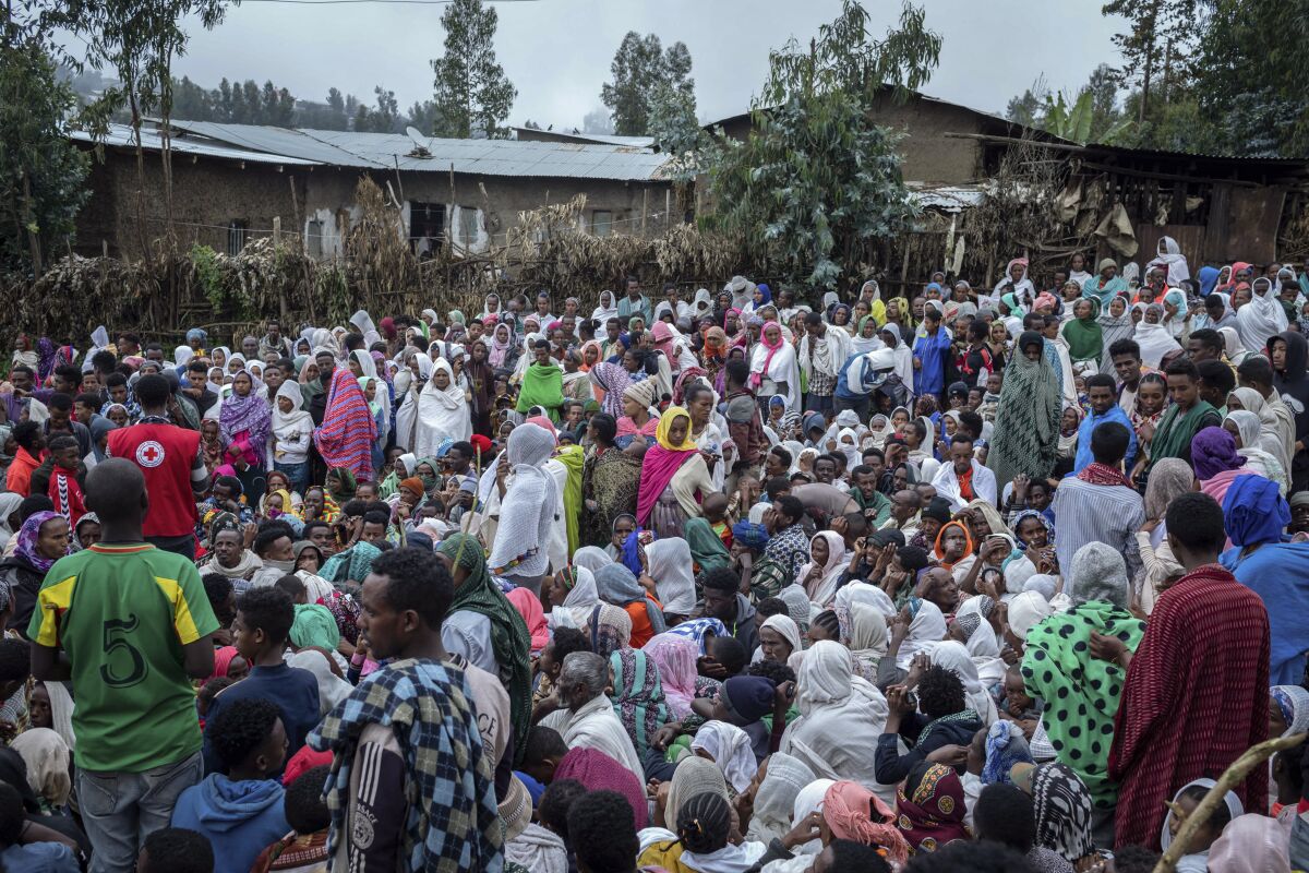 Displaced Ethiopians from different towns in the Amhara region wait for aid distributions at a center for the internally-displaced in Debark, in the Amhara region of northern Ethiopia Friday, Aug. 27, 2021. As they bring war to other parts of Ethiopia such as the Amhara region, resurgent Tigray fighters face growing allegations that they are retaliating for the abuses their people suffered back home, sending hundreds of thousands of people fleeing in the past two months. (AP Photo/Mulugeta Ayene)