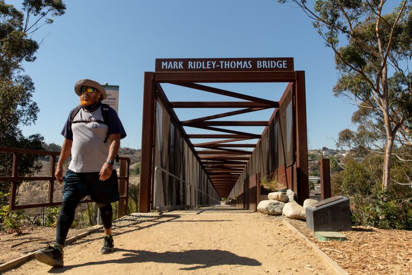 LOS ANGELES CA OCTOBER 14, 2021 - Hikers walk across the Mark Ridley-Thomas Bridge, which stretches over La Cienega Boulevard, and links Kenneth Hahn Park to the Stoneview Nature Center. (Allison Zaucha / For The Times)