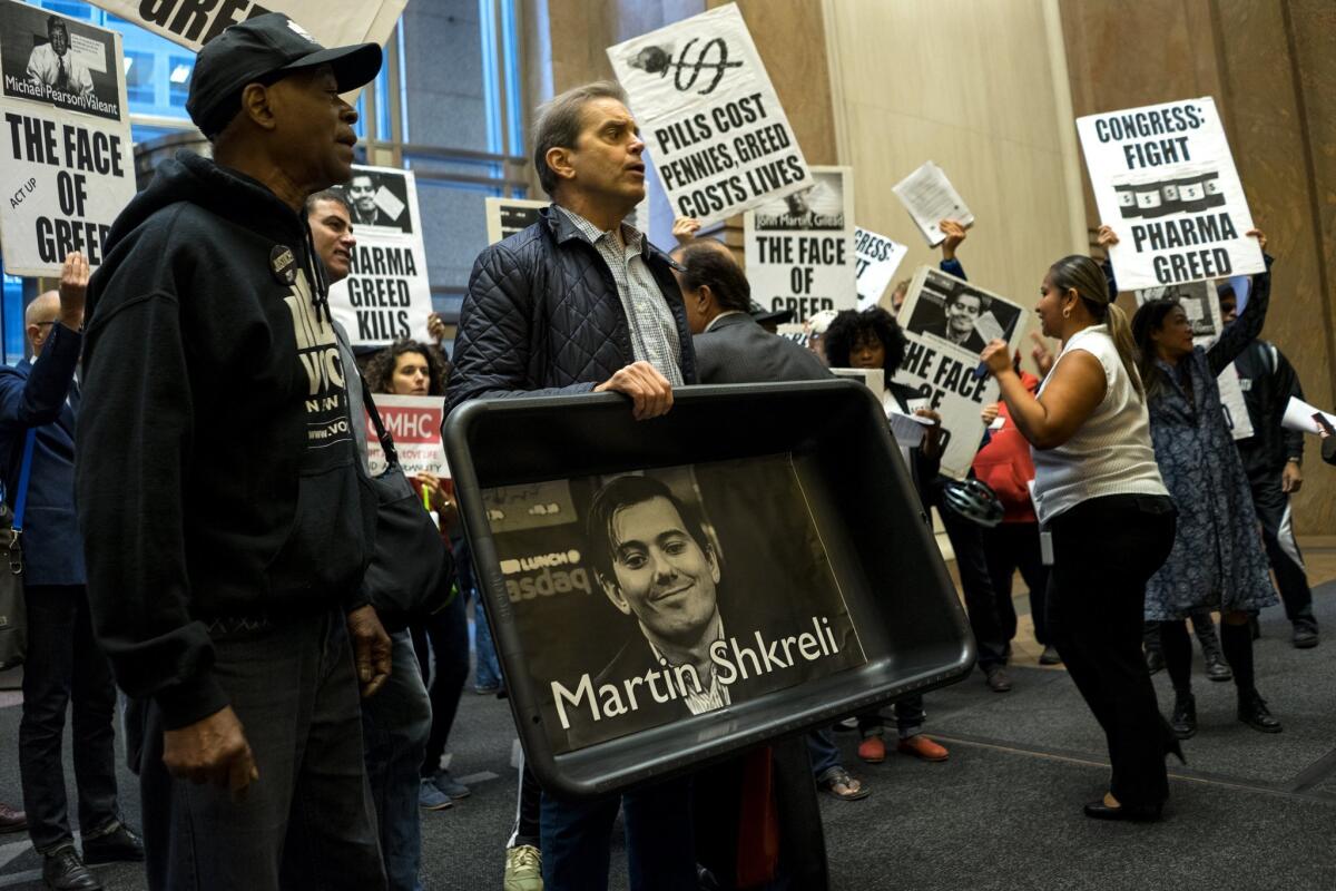 An AIDS activist carries an image of Turing Pharmaceuticals CEO Martin Shkreli during a protest against pharmaceutical drug pricing.