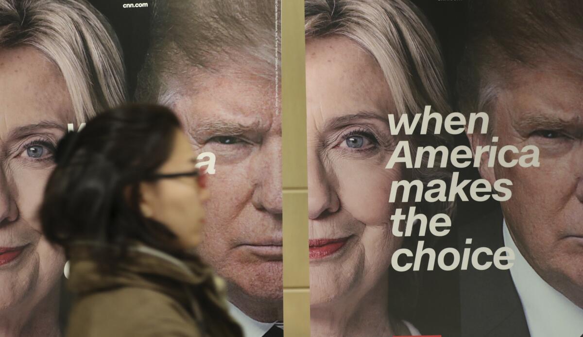 A woman walks by banners promoting CNN's coverage of the presidential election, in this file photo taken on Nov. 9, 2016.