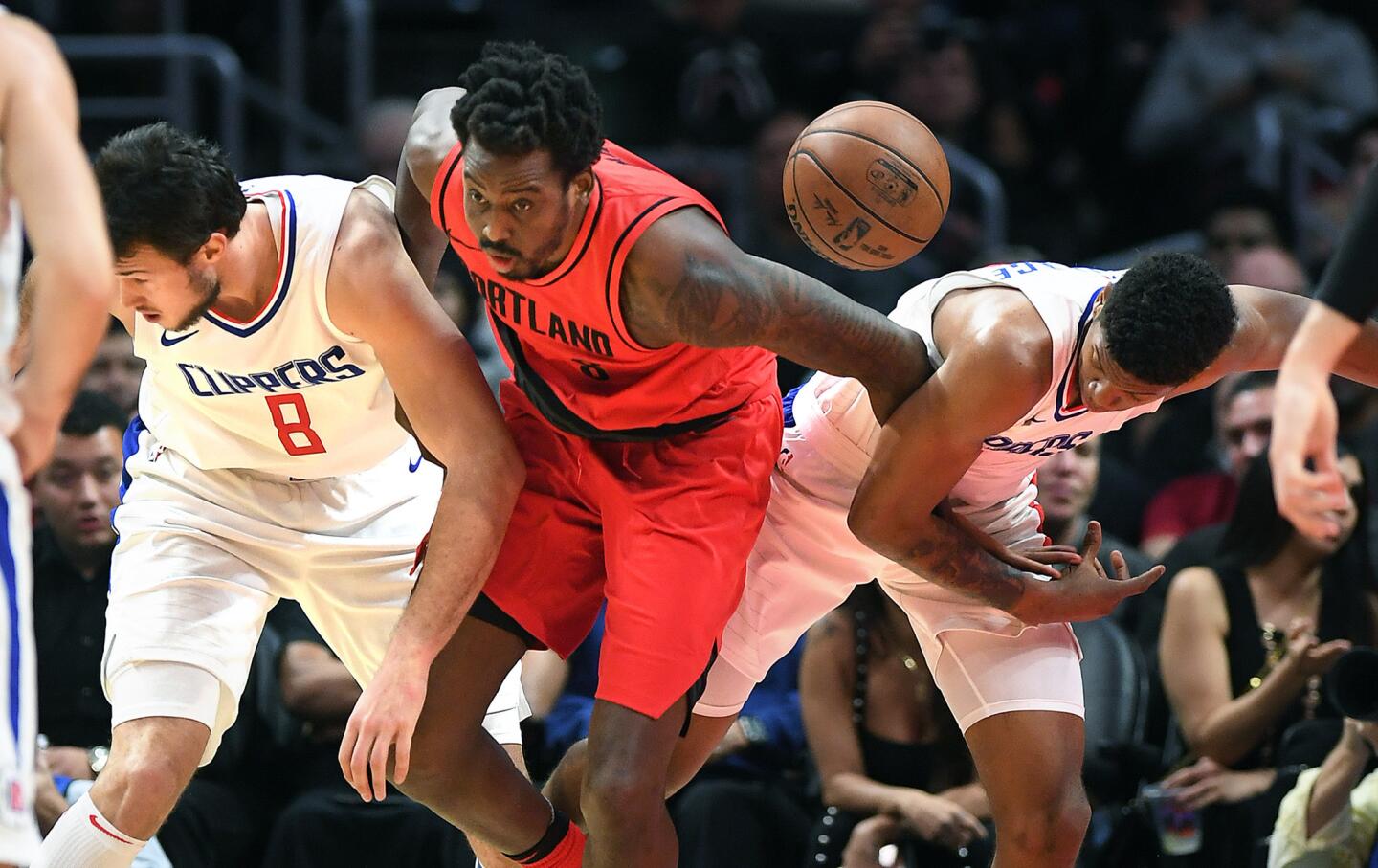 Clippers Danilo Gallinari, left, and Tyrone Wallace battle for a loose ball with Trail Blazers' Al-Farouq Aminu in the 4th quarter.