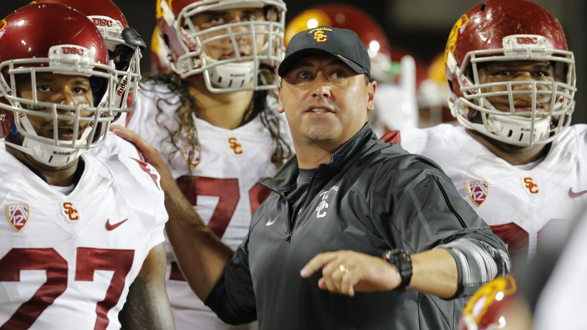 USC Coach Steve Sarkisian speaks with his players before a 28-26 win over Arizona on Saturday.