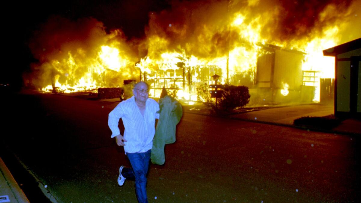 Sylmar resident Brian Demetz runs from his burning home in Sylmar on Jan. 17, 1994, after the Northridge earthquake.