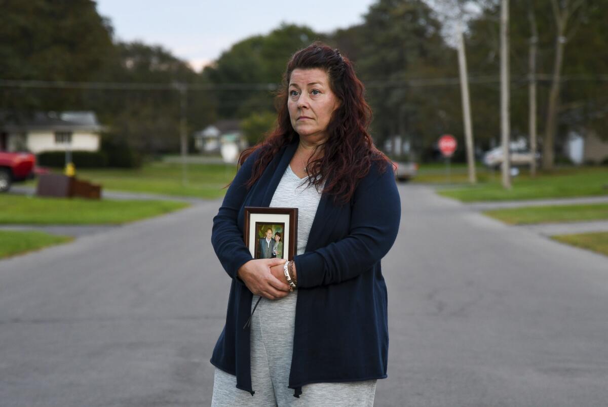 Natalie Walters, 53, holds a photo of her parents, Jack and Joey Walters, near her home in Syracuse, N.Y., Tuesday, Sept. 21, 2021. Walters' father, who was staying at the Loretto Health and Rehabilitation nursing home in Syracuse, died of COVID-19 in December 2020. The facility's staffing has declined during the pandemic and Walters wonders if poor staffing played a role in her father's infection or death. Nationwide, one-third of U.S. nursing homes have fewer nurses and aides than before COVID-19 began ravaging their facilities, an Associated Press analysis of federal data finds. (AP Photo/Heather Ainsworth)