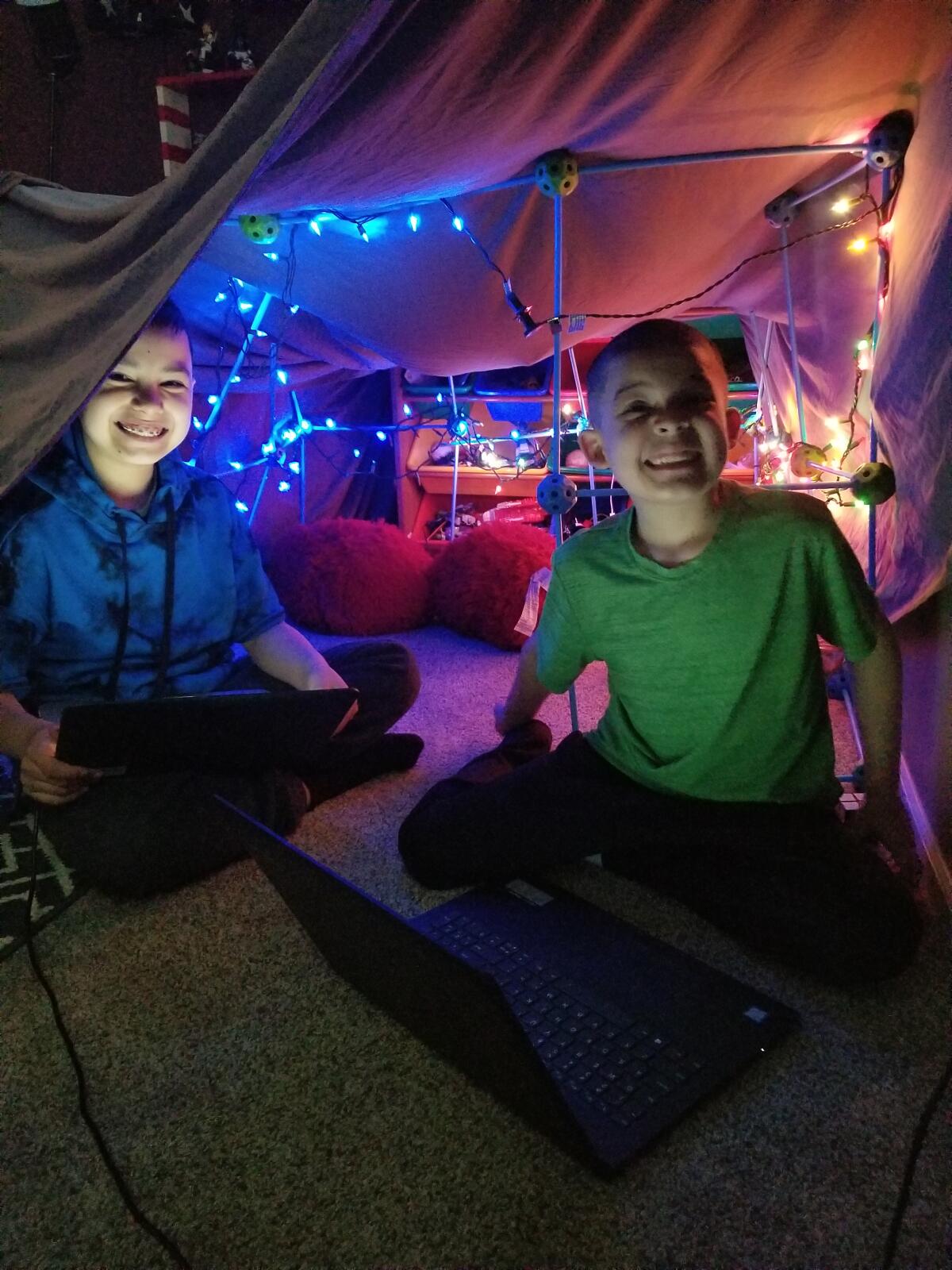 Children do their schoolwork in a fort at home due to school closures amid coronavirus concerns.