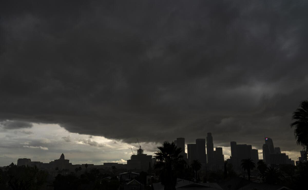 Heavy dark clouds move over the downtown Los Angeles skyline. 