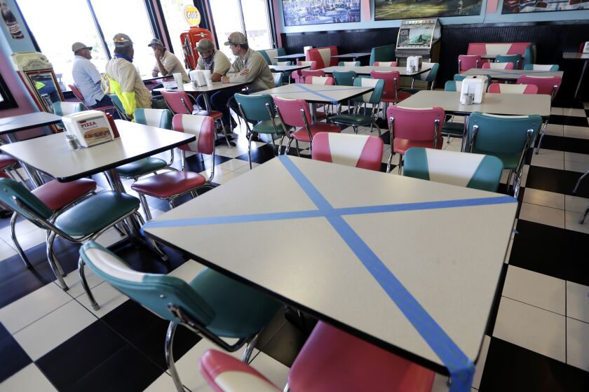 Tables are marked off for social distancing at Hwy 55 Burgers Shakes & Fries Monday, April 27, 2020, in Nolensville, Tenn. Monday is the first day Tennessee restaurants can reopen with reduced seating and social distancing during the coronavirus pandemic. (AP Photo/Mark Humphrey)