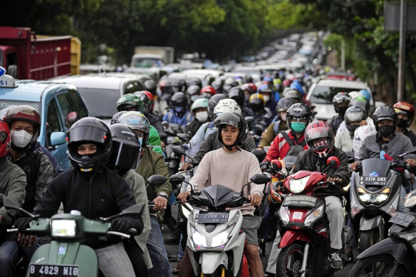 Automovilistas y motociclistas permanecen varados durante la hora pico del tránsito matutino en Yakarta,