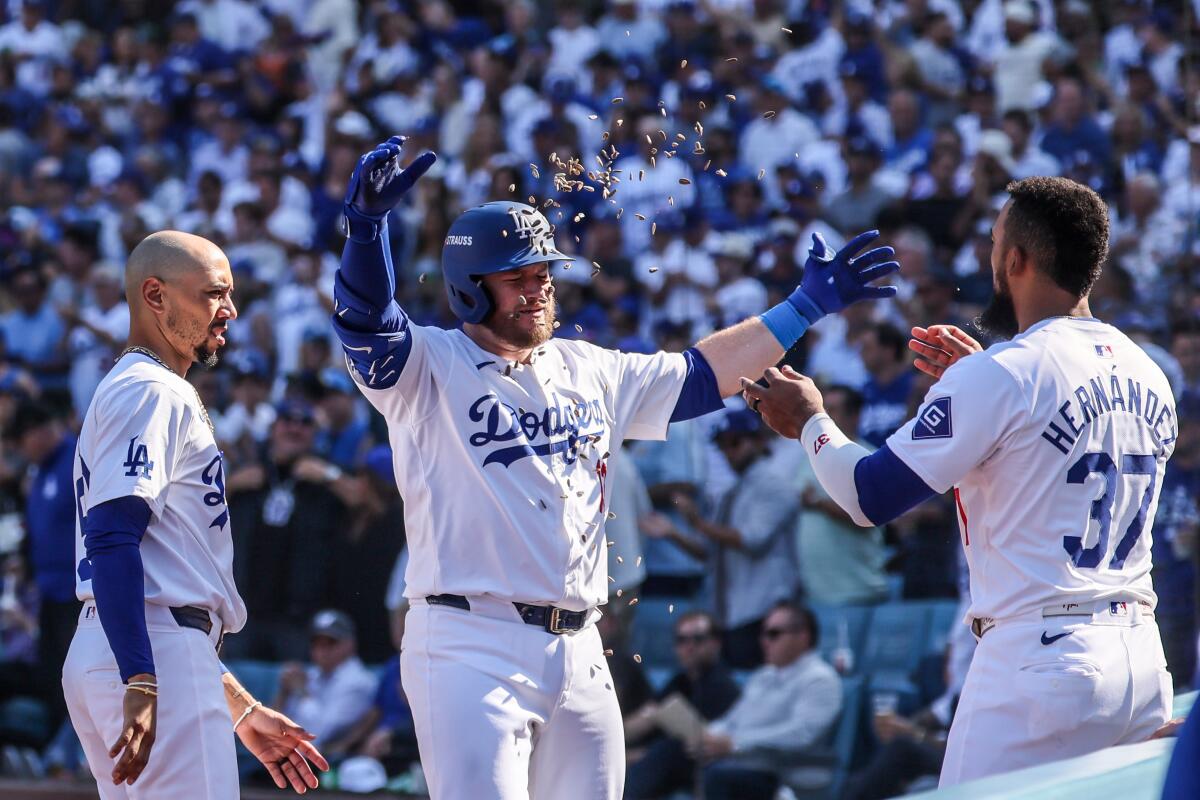 Dodgers third baseman Max Muncy is showered with sunflower seeds by teammate Teoscar Hernández.