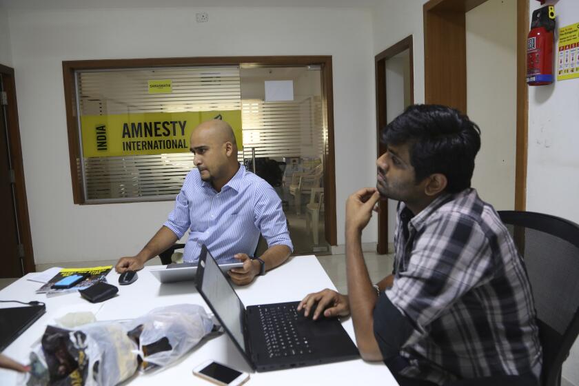 FILE - In this Tuesday, Feb. 5, 2019, file photo, Amnesty International India employees work at their headquarters in Bangalore, India. The Human rights watchdog said on Tuesday, Sept. 29, 2020, that it was halting its operation in India, citing reprisals from the government and the freezing of its bank accounts. Its announcement comes at a time amid growing concerns over the state of free speech in India where critics accuse Prime Minister Narendra Modi and his Hindu nationalist government of increasingly brandishing laws to silence human rights activists, intellectuals, filmmakers, students and journalists. (AP Photo/Aijaz Rahi, File)