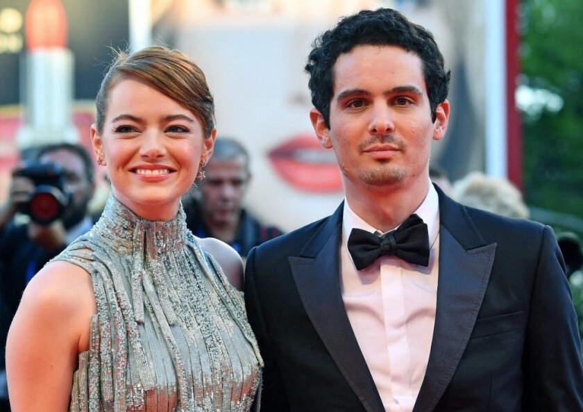 Actress Emma Stone, left, and director Damien Chazelle pose on the red carpet for the film "La La Land" that opens the 73rd Venice Film Festival in Venice, Italy, Aug. 31 2016.