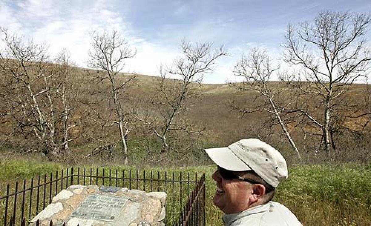 Dave Raetz, director of public programs with the Irvine Ranch Conservancy, stands near the Hangman's Tree and monument, which sits about 100 yards from the Foothill Toll Road.