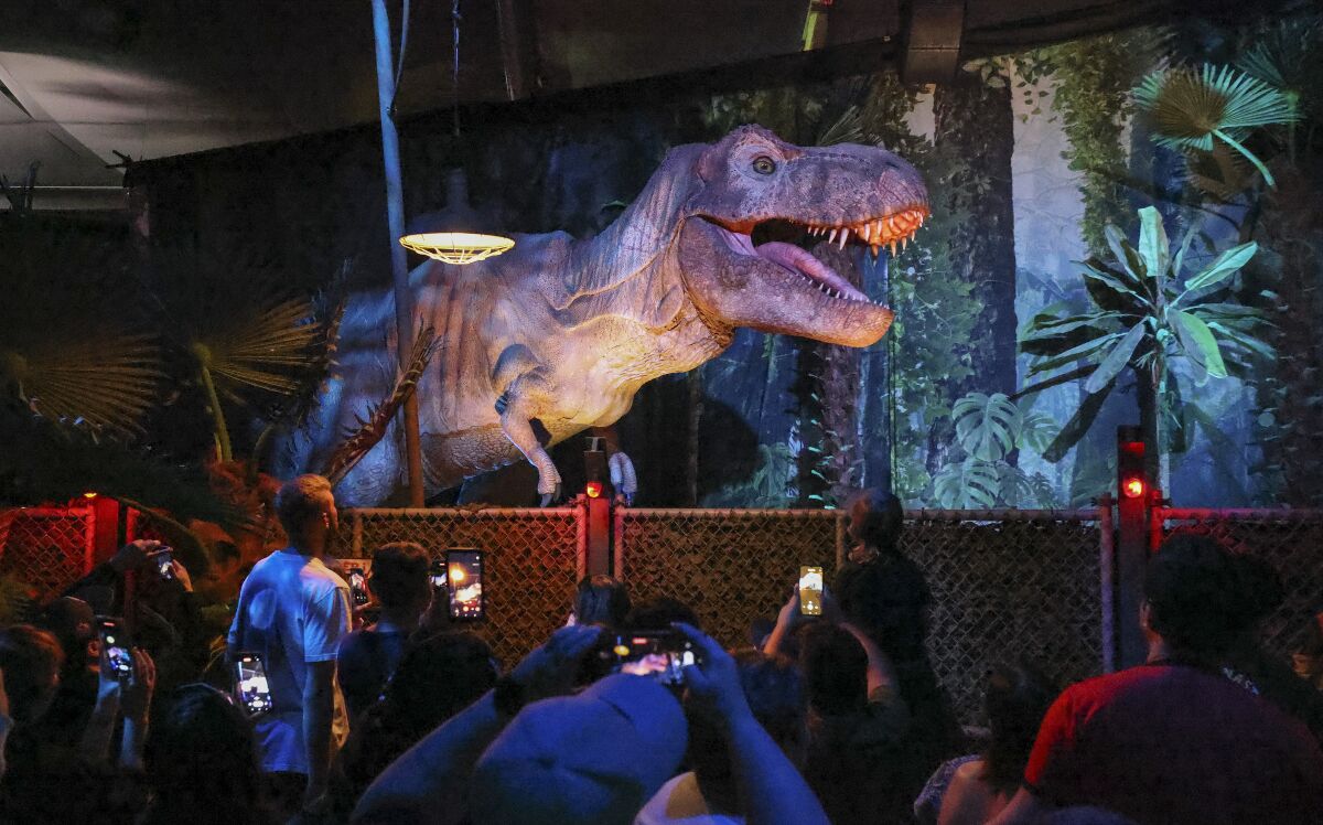 A crowd watches a Tyrannosaurus rex at the Jurassic World: Exhibition on October 28 in San Diego.