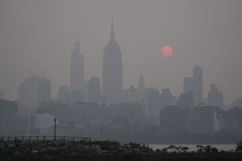 El sol se levanta sobre el horizonte en la ciudad de Nueva York en medio de una bruma, en una vista desde Jersey City, Nueva Jersey, el miércoles 7 de junio de 2023. (AP Foto/Seth Wenig)