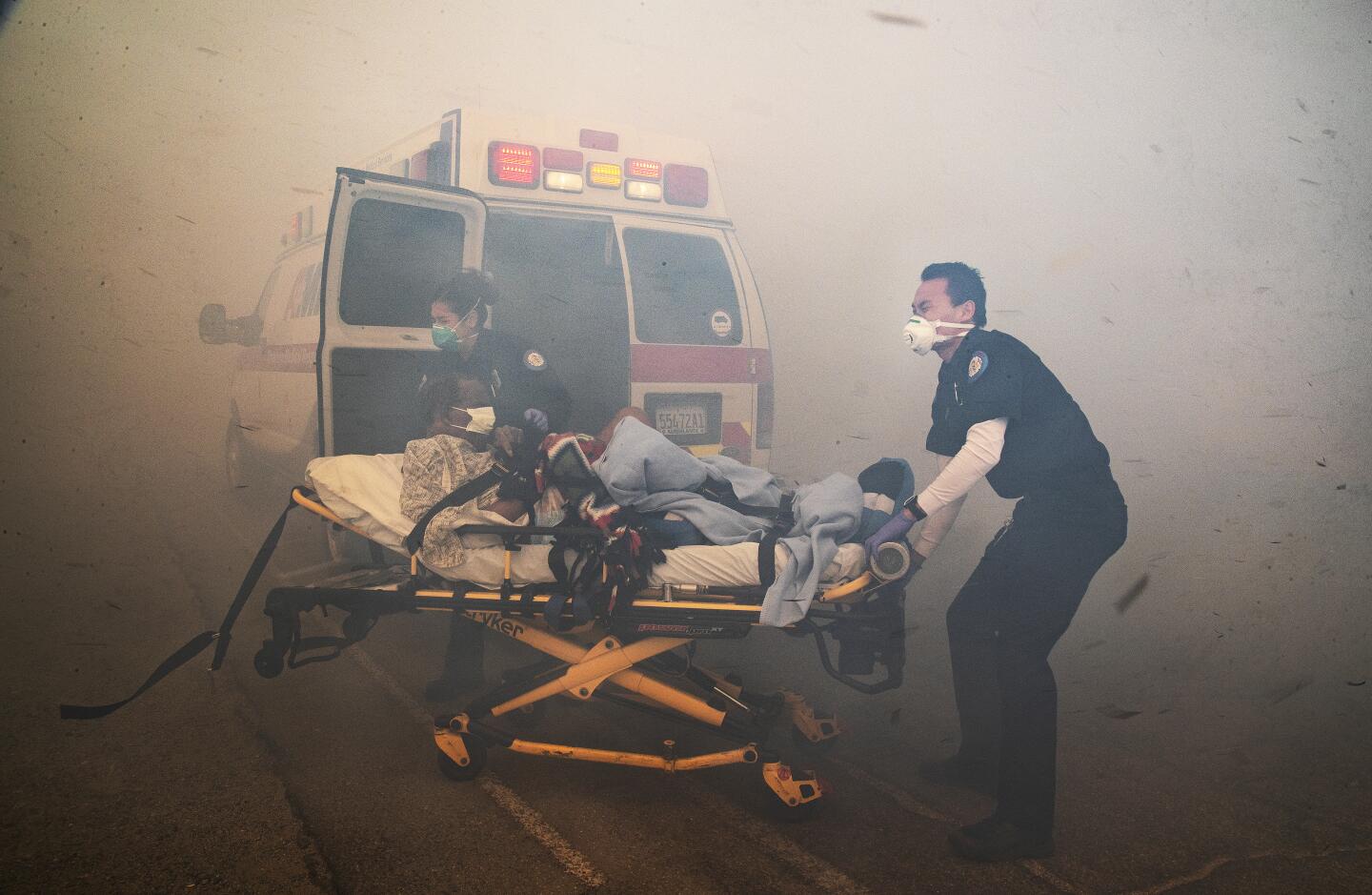 JURUPA VALLEY, CA - OCTOBER 30, 2019: Paramedics battle thick smoke to evacuate a resident from the Riverside Heights Healthcare Center as the Hill fire grows dangerously close to the facility fueled by dry brush and extreme Santa Ana winds on October 30, 2019 in Jurupa Valley California. (Gina Ferazzi/Los AngelesTimes)