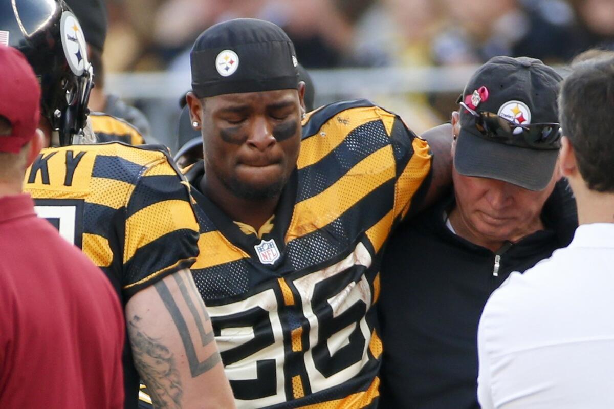 Pittsburgh running back Le'Veon Bell is helped from the field Sunday after being injured in an game against Cincinnati.