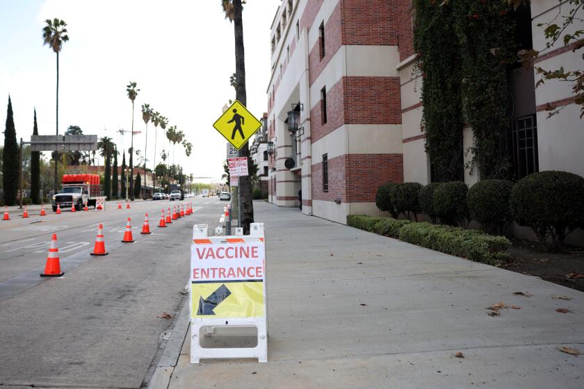 LOS ANGELES, CA - MARCH 11: Signage alerts people to a new vaccine site at USC which is supplied through the city's doses and will be their 7th site in University Park on Thursday, March 11, 2021 in Los Angeles, CA. The site is accessible by bus and expo line, and is walking distance from some of the hard-hit zip codes in South L.A. (Dania Maxwell / Los Angeles Times)