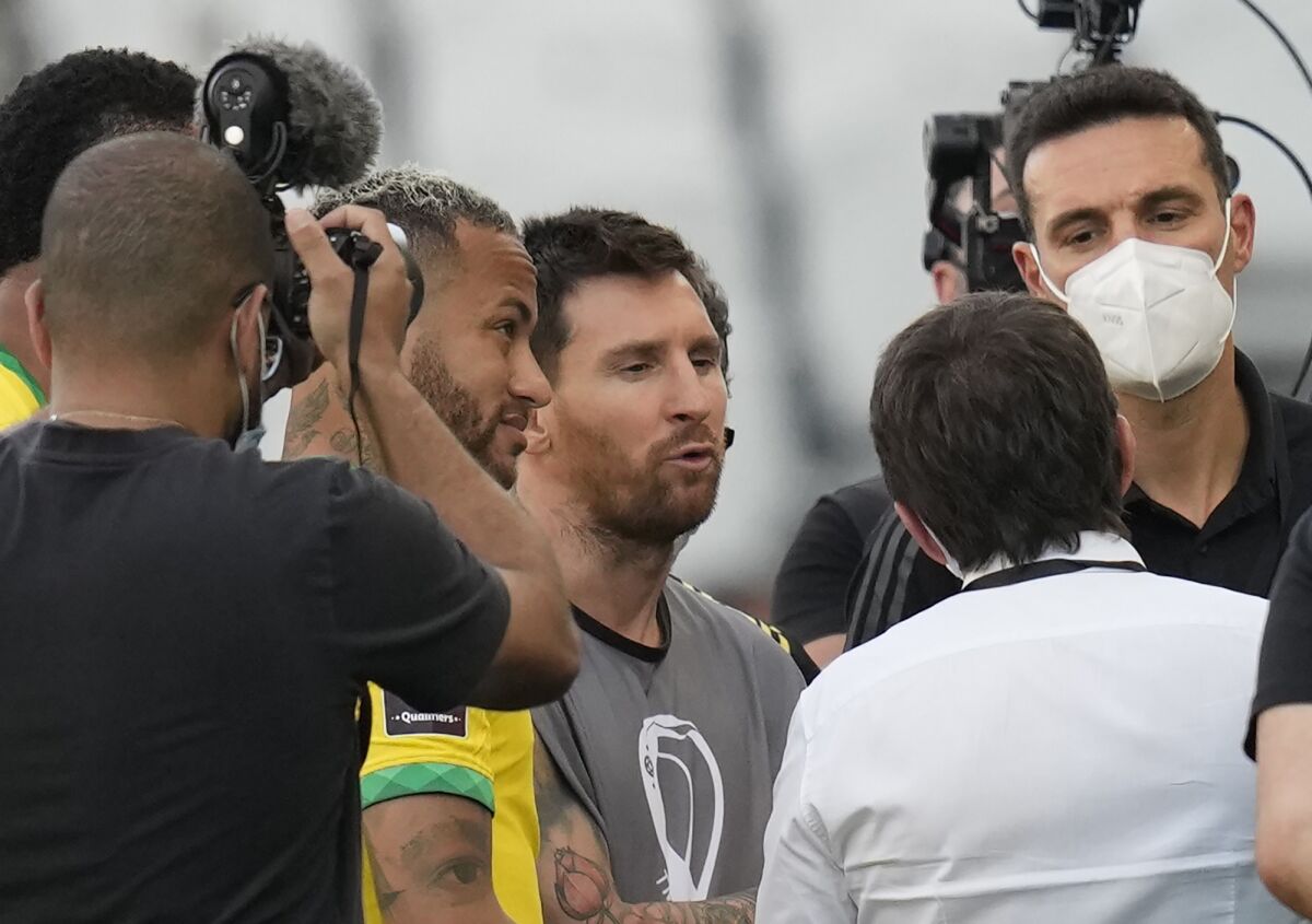 Argentina's Lionel Messi, center, Brazil's Neymar, left, and Argentina's coach Lionel Scaloni talk as the soccer game is interrupted by health authorities during a qualifying soccer match for the FIFA World Cup Qatar 2022 at Neo Quimica Arena stadium in Sao Paulo, Brazil, Sunday, Sept.5, 2021. (AP Photo/Andre Penner)