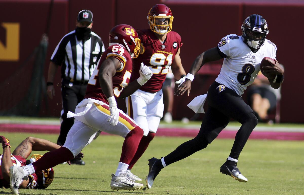 Baltimore Ravens quarterback Lamar Jackson runs by several Washington defenders on Sunday.