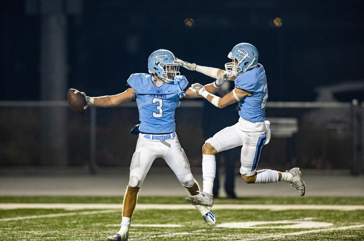 Corona del Mar's Jake Simkins, right, celebrates with Tommy Griffin after recovering a fumble by Newport Harbor on April 2.
