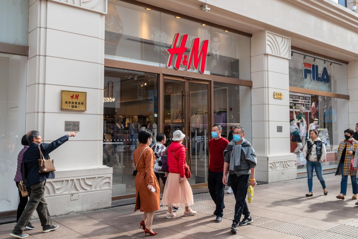 People walk past an H&M store on Nanjing Road in Shanghai, China, March 24. 