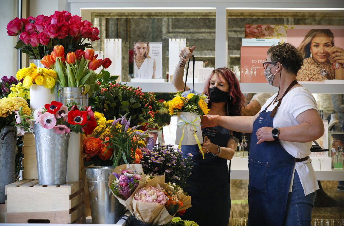 Two women work at a flower stand