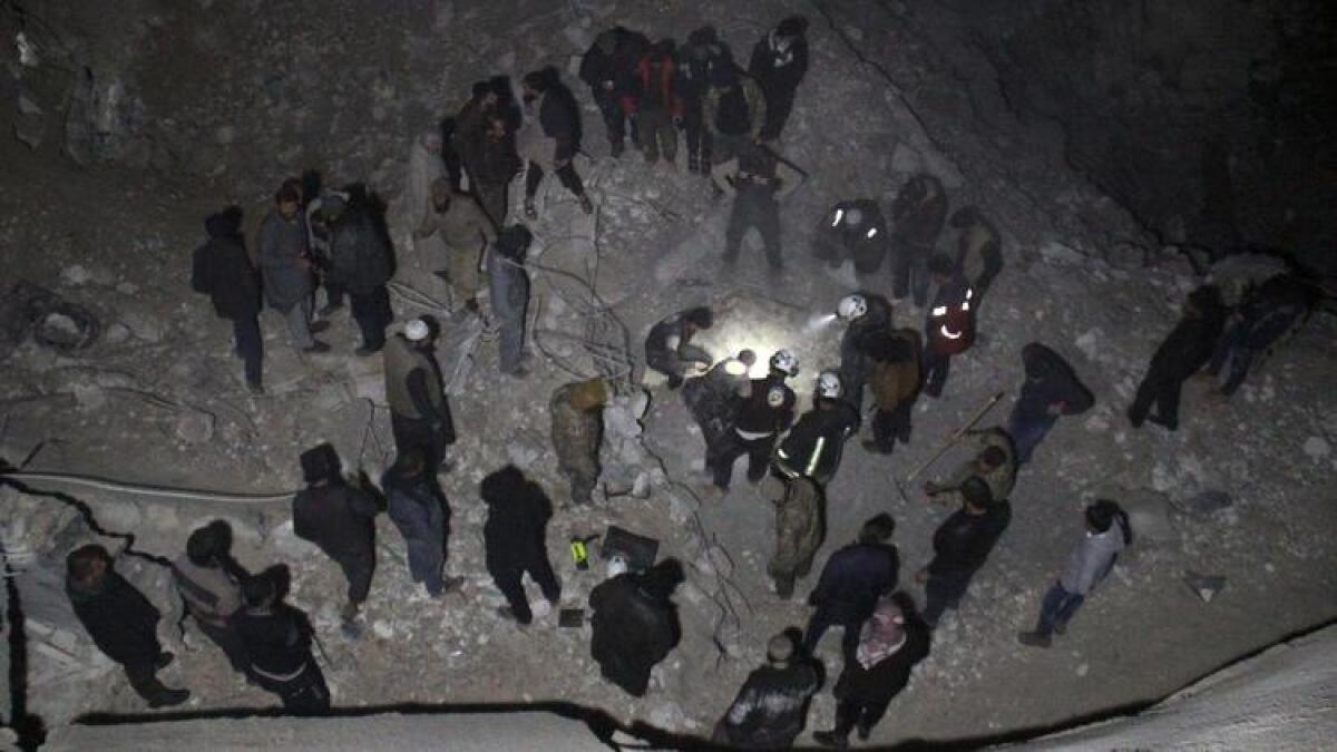 Syrian civil defense volunteers dig through the rubble of a mosque following a reported airstrike late Thursday.