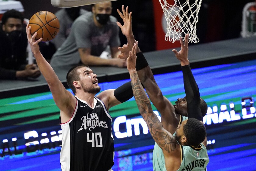 Clippers center Ivica Zubac shoots over Hornets forward P.J. Washington and center Bismack Biyombo.