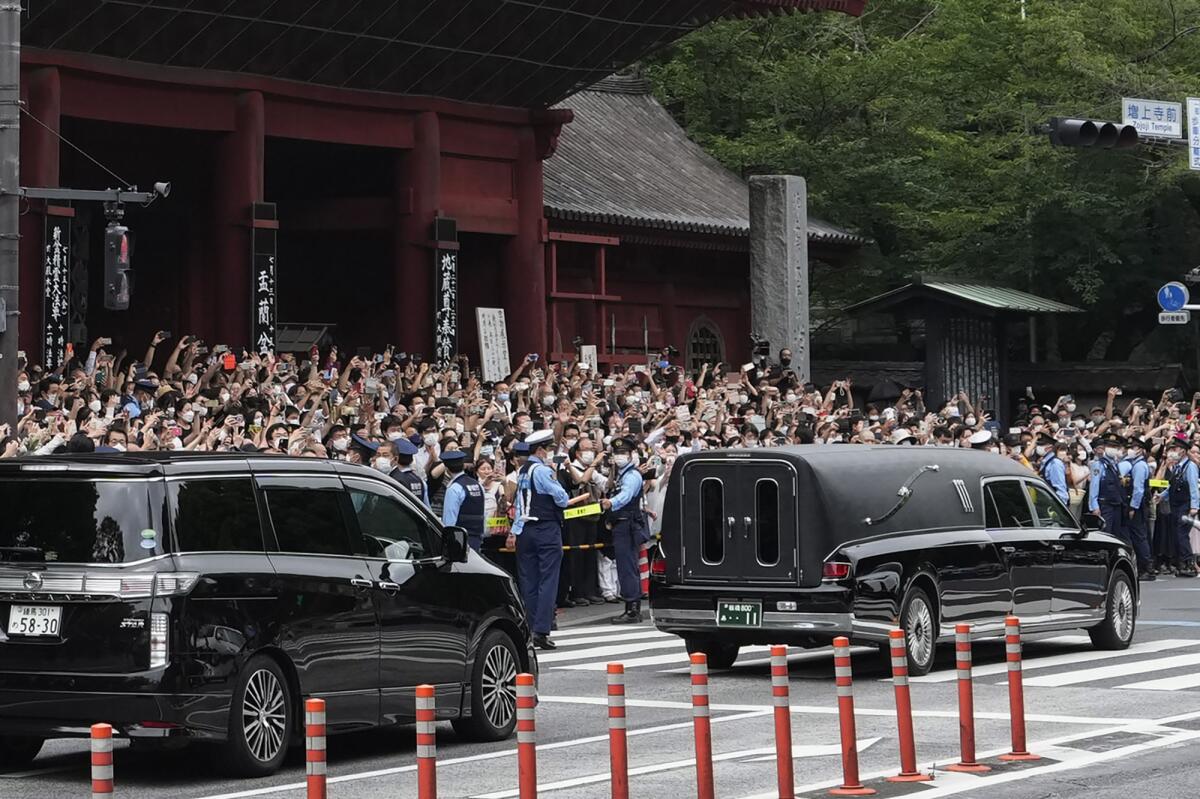 Un auto fúnebre (derecha) con el cuerpo del exprimer ministro de Japón Shinzo Abe