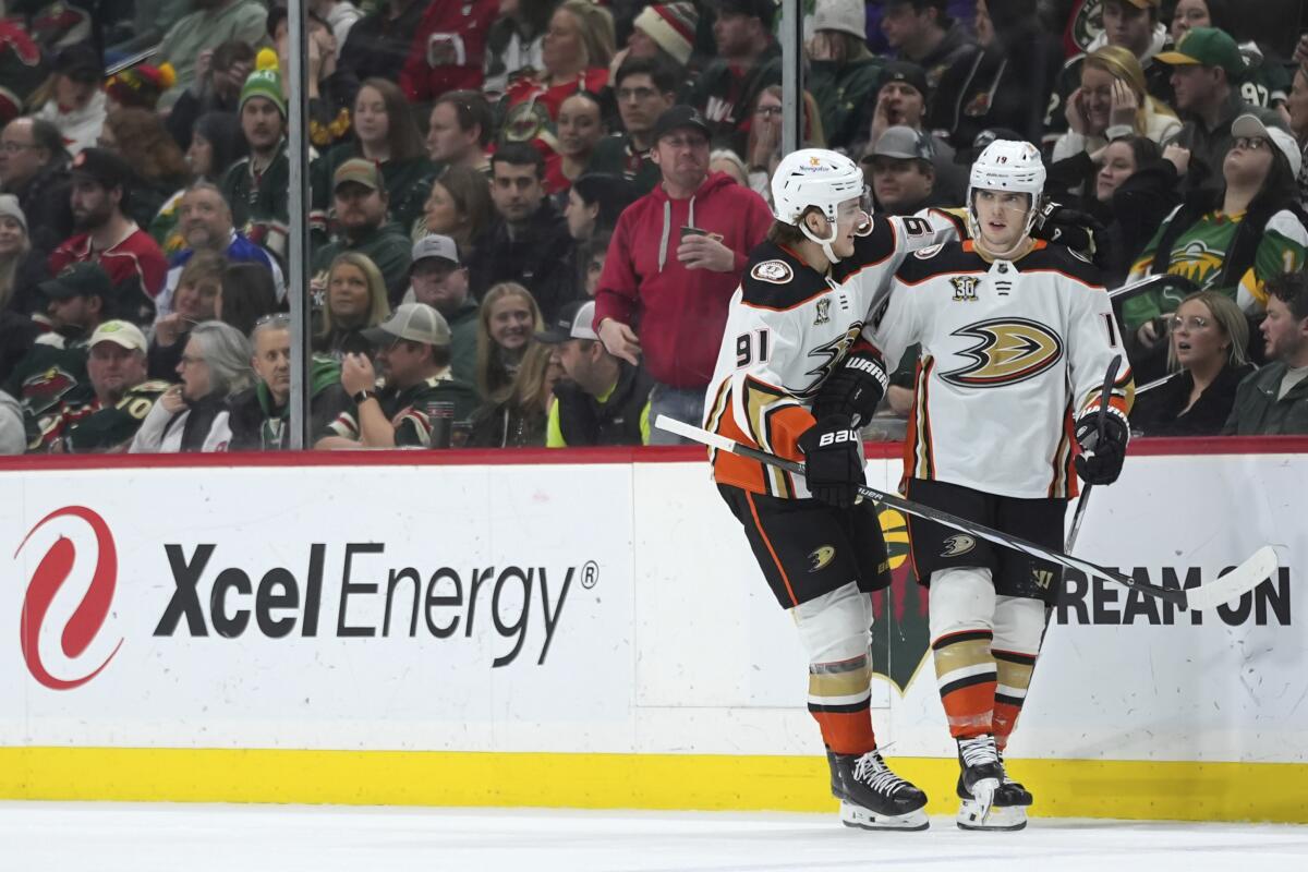 Ducks right wing Troy Terry, right, celebrates with center Leo Carlsson after scoring against Minnesota.