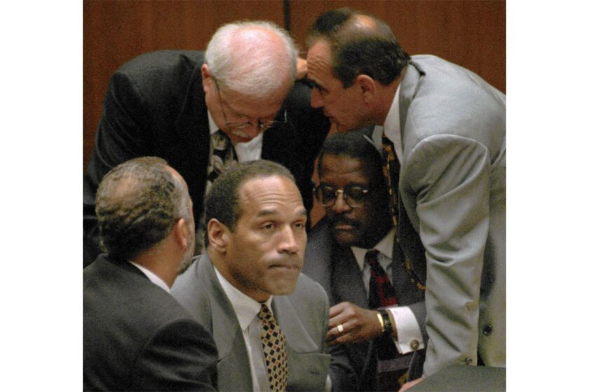 O.J. Simpson's defense team huddles around him in court on Aug. 29, 1995.
