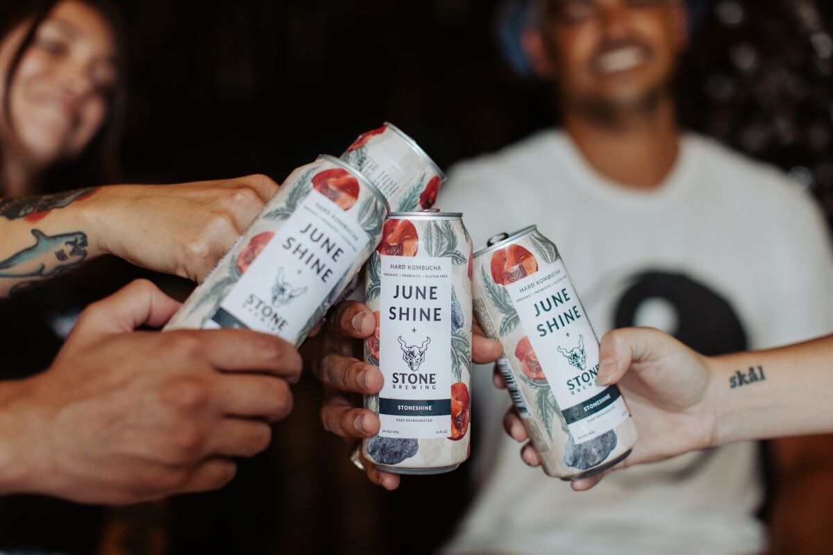 People drinking cans of StoneShine, a new product from JuneShine Hard Kombucha and Stone Brewing