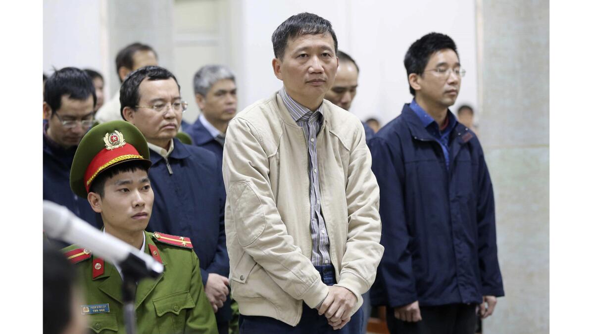 Trinh Xuan Thanh, center, listens during his embezzlement trial in Hanoi. Prosecutors are seeking life imprisonment for Thanh, the former chairman of a construction company tied to state energy giant PetroVietnam.