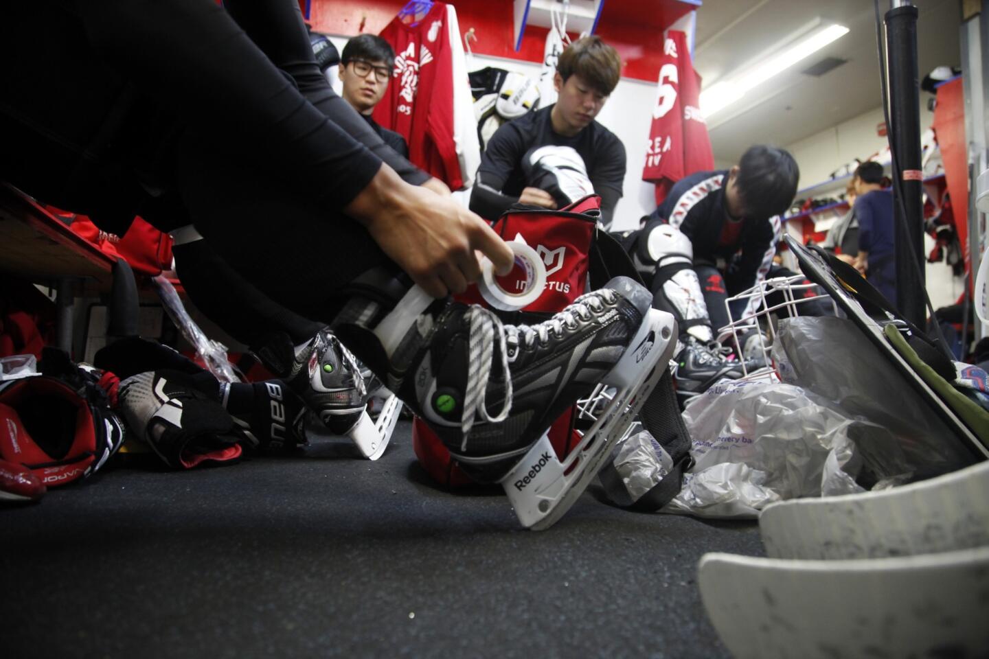 Hockey players from Korea University lace up their skates before taking part in a training session in Lakewood on July 30. The players are training in the United States to prepare for the 2018 Winter Olympic Games, which will be held in South Korea.