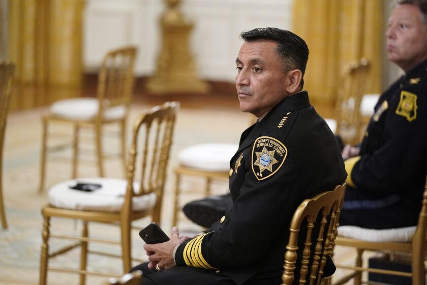 Bernalillo County Sheriff Manuel Gonzales, left, and Kansas City police Chief Rick Smith, wait for an event on "Operation Legend: Combatting Violent Crime in American Cities," to begin in the East Room of the White House, Wednesday, July 22, 2020, in Washington. (AP Photo/Evan Vucci)
