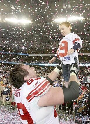 Giants offensive lineman Rick Seubert celebates with his son Hunter after New York defeated the New England Patriots, 17-14, in Super Bowl XLII at University of Phoenix Stadium on Sunday.