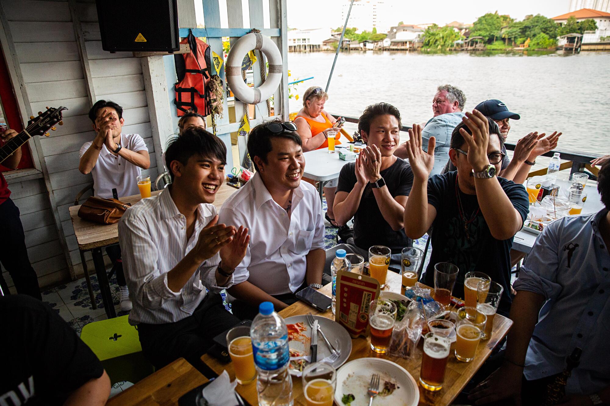 Patrons clap on the veranda of Chit Beer in February 2020.