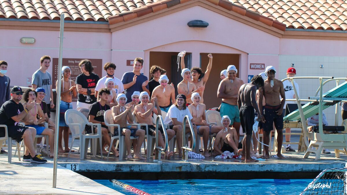 Members of the La Jolla High School football team cheer on their teammates in the pool during the 2021 "Tangle in the Tank."