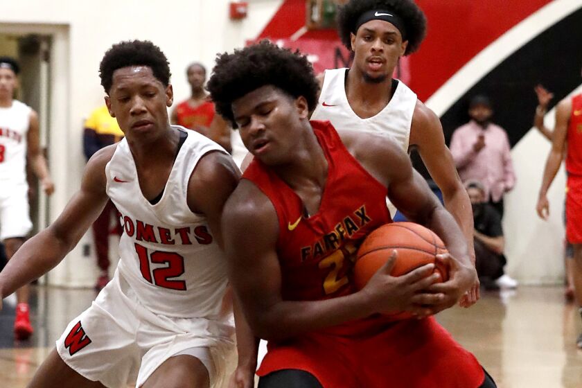 LOS ANGELES, CALIF. - JAN. 25, 2019. Westchester guard Kevin Bethel tries to swat the ball away from Fairfax guard Ethan Anderson in the second half Friday night, Jan. 25, 2019, at Westchester High. (Luis Sinco/Los Angeles Times)