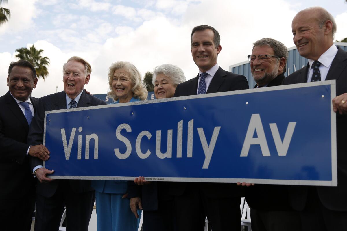 Vin Scully, second from left, holds a new street sign.