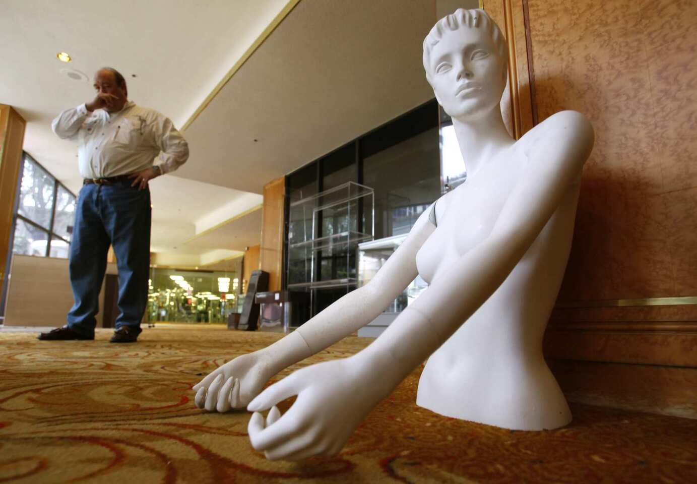 Frank Long, president of International Content Liquidations, stops in the hallway near a mannequin on sale for $15 at the Wilshire Grand Hotel.