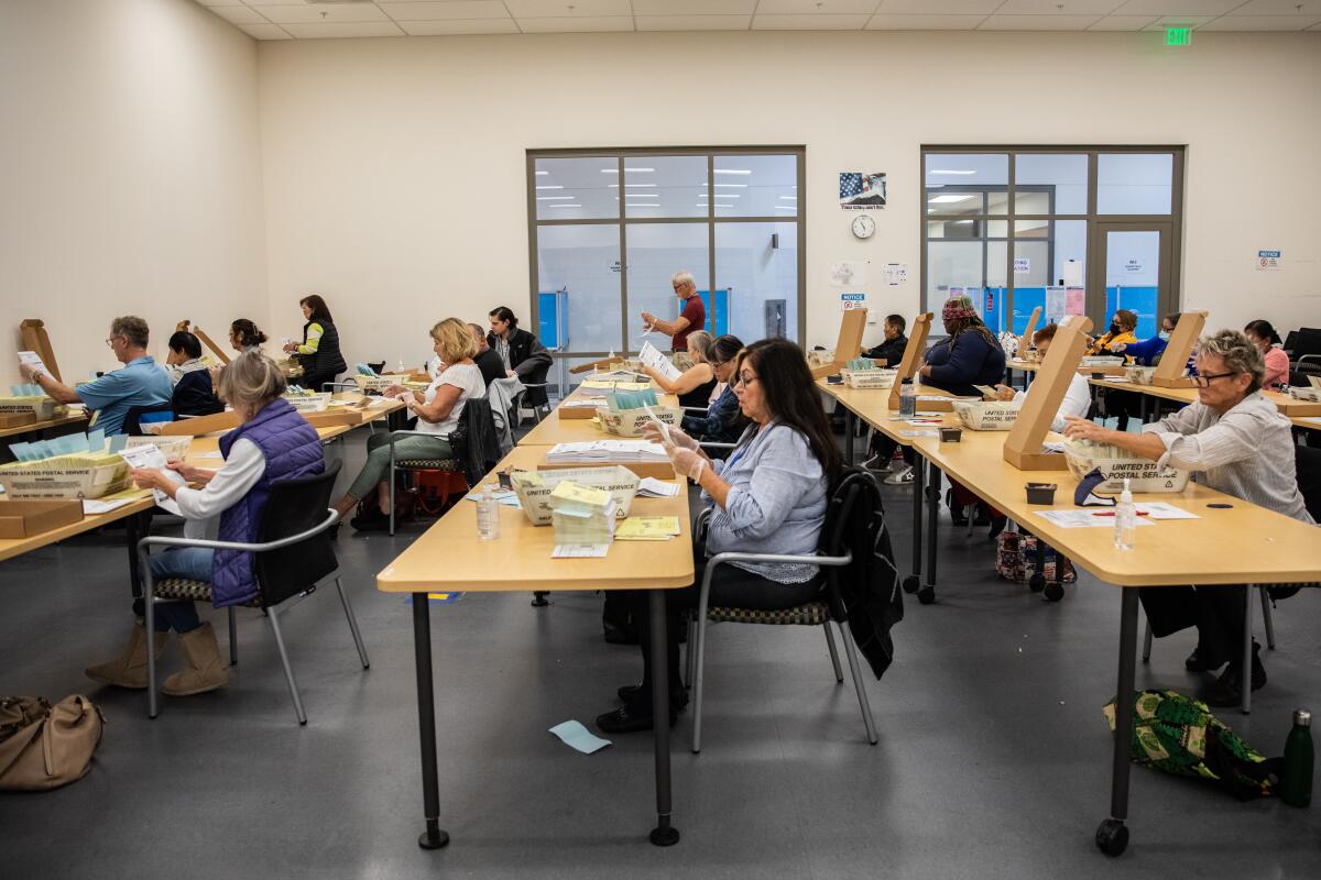 Poll workers sort and process mail-in ballots at the San Diego County registrar of voters office.