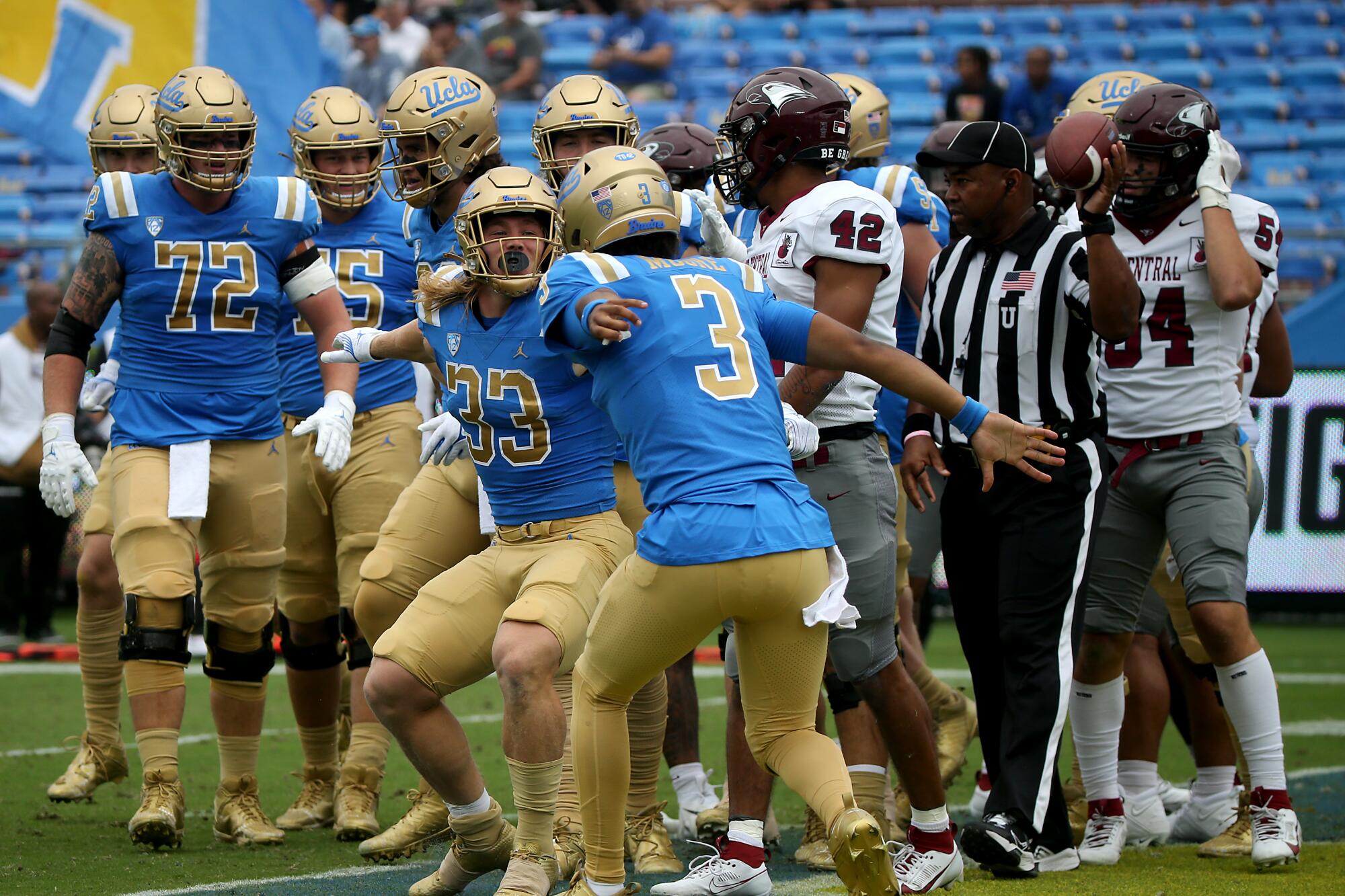 UCLA running back Carson Steele prepares to jump in the air with quarterback Dante Moore while teammates watch.