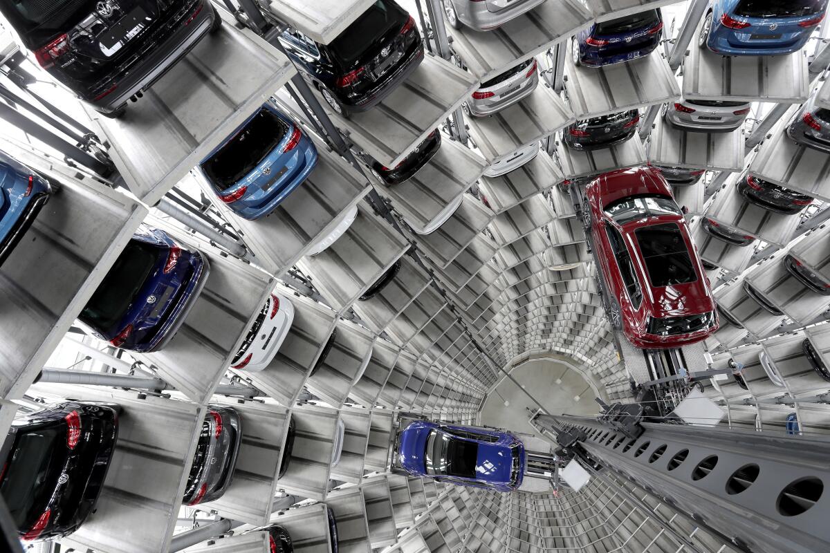 FILE - In this March 14, 2017 file photo Volkswagen cars are lifted inside a delivery tower of the company in Wolfsburg, Germany. German automaker Daimler on Friday dismissed a “cease and desist” demand from two environmental groups to commit to ending the sale of combustion engine vehicles by 2030. Lawyers for Greenpeace and the group Deutsche Umwelthilfe have threatened to sue Daimler, BMW and Volkswagen unless they sign a legal pledge not to put new gas-fueled vehicles onto the market from the end of this decade. (AP Photo/Michael Sohn, file)